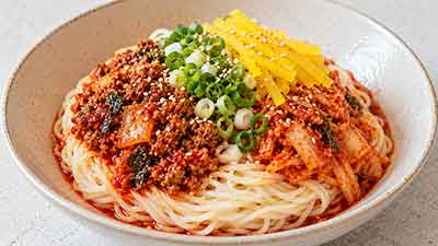 매콤한 양념과 달걀지단, 쪽파가 올려진 비빔국수