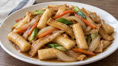 접시에 담긴 채소와 함께 볶은 간장떡볶이
